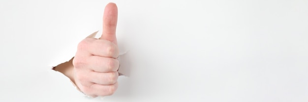 Female hand makes thumbs up gesture closeup