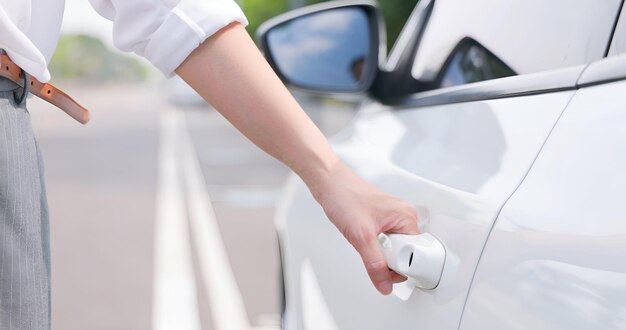 Female hand open the white car on key system automatic