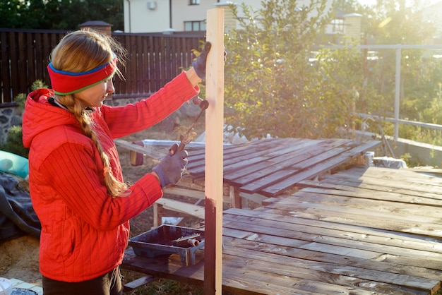 Foto legno dipinto a mano femminile con rullo di vernice