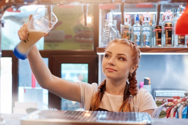 Female hand pouring beer from tap