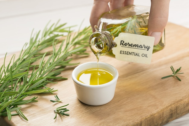 Female hand pouring Rosemary essential oil