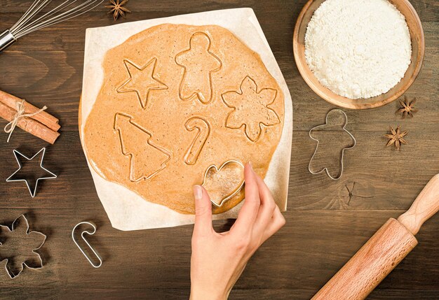 Female hand preparing christmas gingerbread, top view