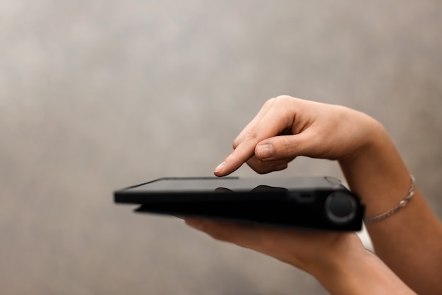 Photo female hand presses on the screen of a digital tablet closeup