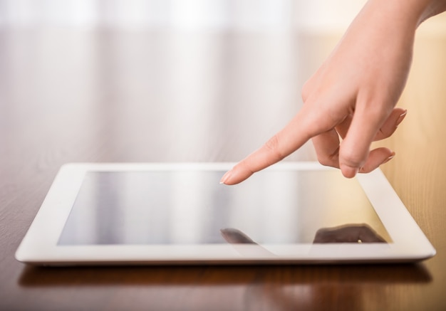Photo female hand presses on screen digital tablet.