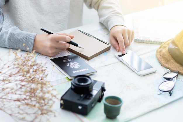 Foto smartphone femminile di stampaggio a mano. acquisto di biglietti online e pianificazione del viaggio.