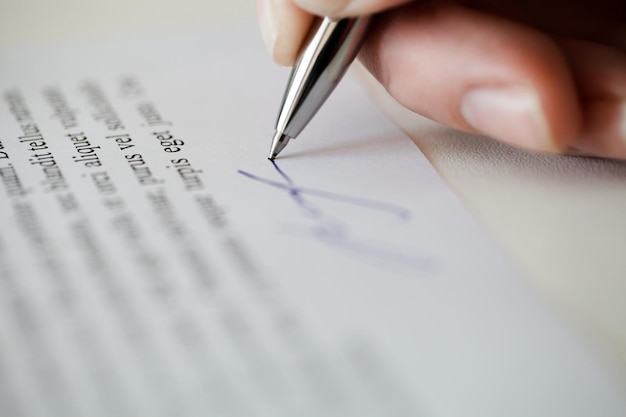 Женская рука ставит образец документа подписи или контракт с текстом lorem ipsum избирательный фокус
