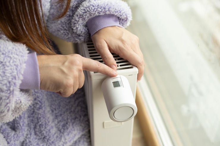 Photo female hand on radiator one hand pointing to thermostat