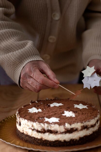 Foto una mano femminile rimuove una stella dopo aver spruzzato una torta di zucchero in polvere