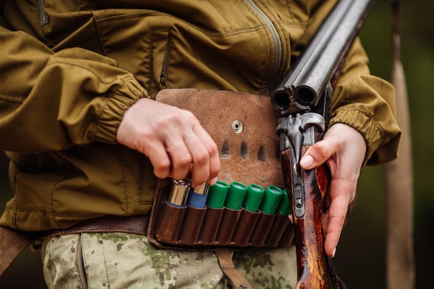 Female hand selected cartridge from the bandolier to charge a hunting rifle