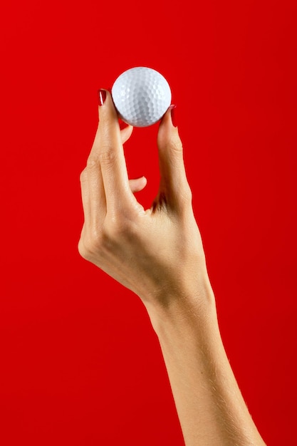 Женская рука показывает мяч для гольфа