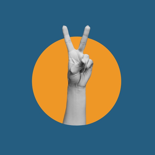 Female hand showing a peace gesture isolated on a dark blue with orange circle color background