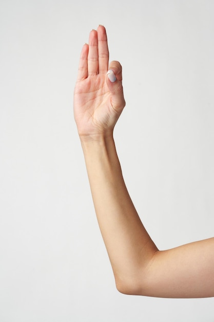 Female hand showing three fingers against white background