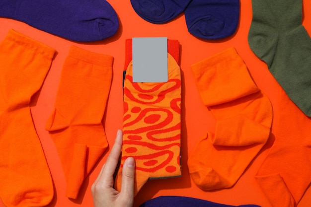 Photo female hand and socks on orange background