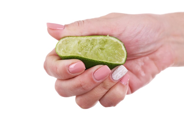 Female hand squeezing lime isolated on white