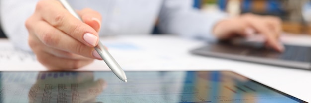 Female hand studying information on digital tablet with stylus closeup