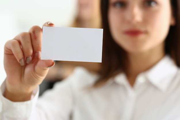 Female hand in suit give blank calling card to visitor