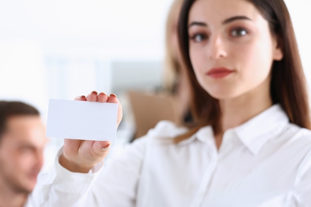 Female hand in suit give blank calling card to visitor