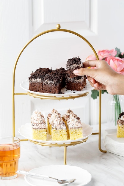 Mano femminile prendere la torta al cioccolato da un concetto di torta high tea rier tè pomeridiano inglese