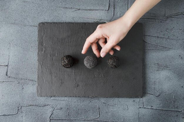 female hand takes a healthy candy from a tray dark mood photo