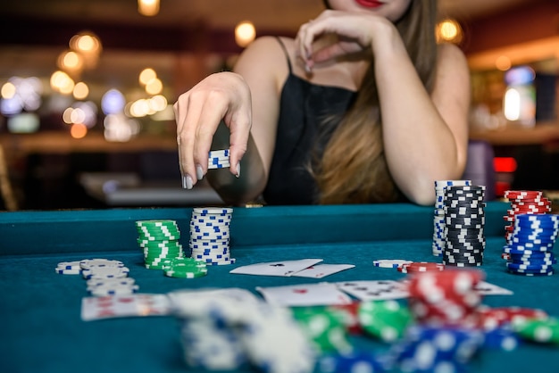 Female hand taking poker chips from pile