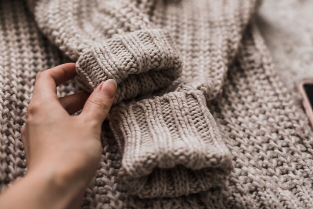 Female hand touching a warm and soft sweater