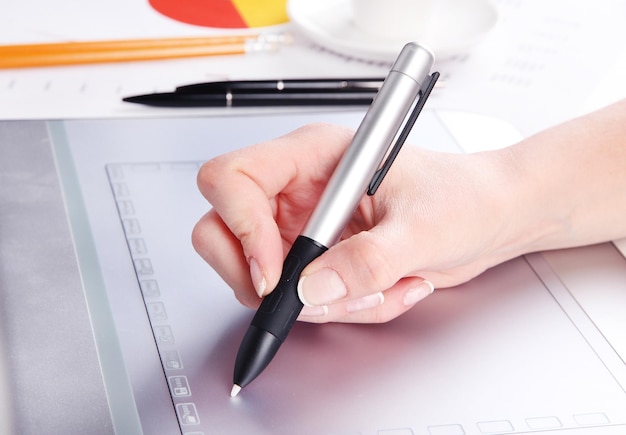 Female hand using graphics tablet on table close up