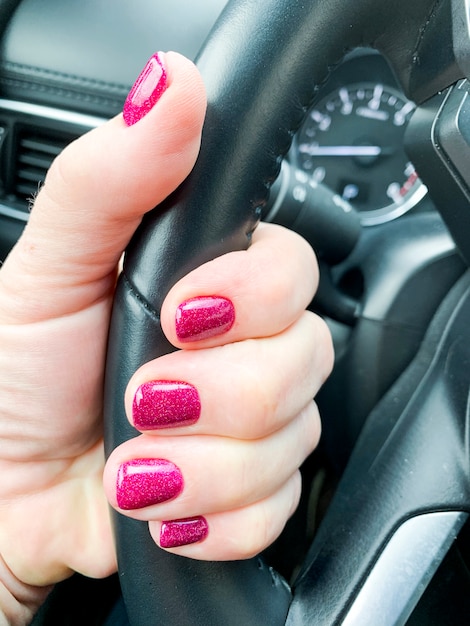 Female hand with beautiful manicure in car