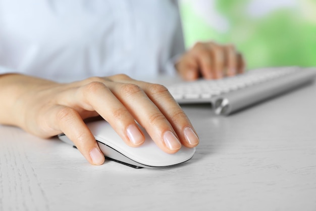 Female hand with computer mouse on table closeup