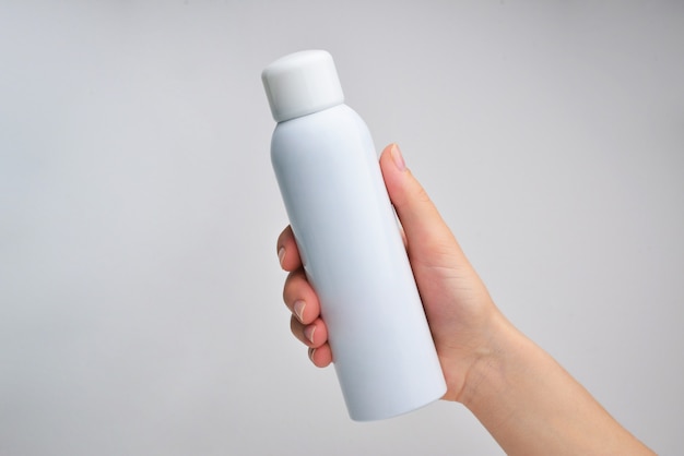 Photo female hand with cosmetics bottle isolated on white