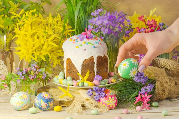 Female hand with Easter eggs Table decorating for Easter holiday