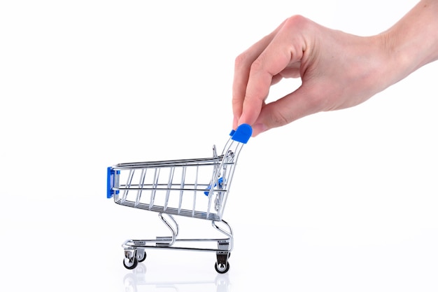 Female hand with fingers pushing a shopping cart isolated on white background. Copy space.