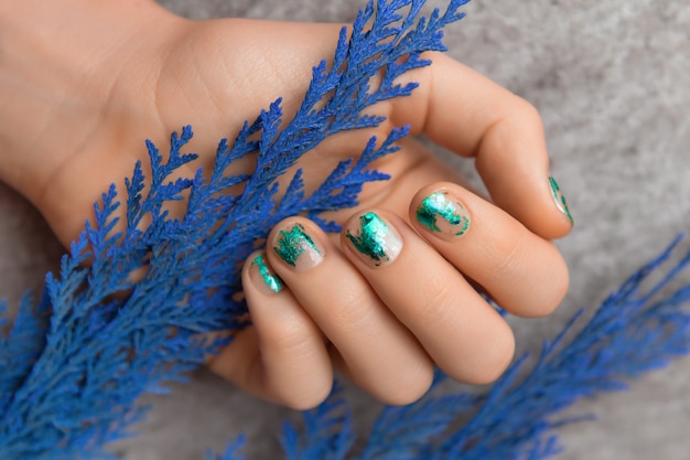 Female hand with green foil nail design