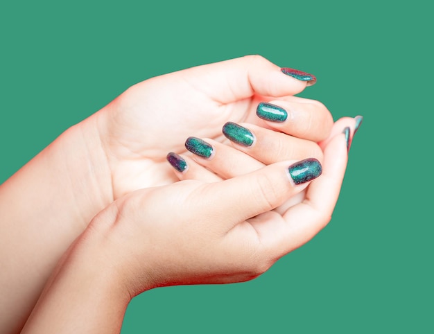 Mano femminile con il design delle unghie verde su sfondo verde donna manicure è arte bella stile estivo primo piano delle dita di bellezza sana giovane ragazza