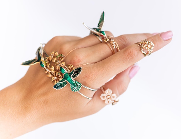 Female hand with jewelry on a neutral white background.