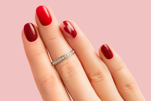 Female hand with manicure on pink background