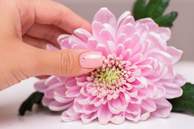 Photo female hand with nude manicure nails