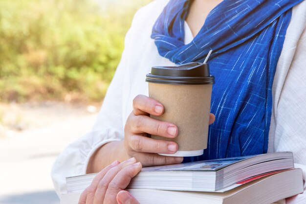 Female hand with paper cup of coffee take away,paper coffee cup in women's hands with perfect manicure