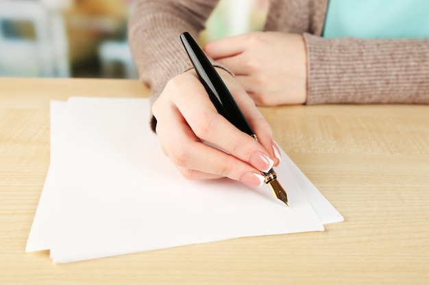 Female hand with pen writing on paper closeup