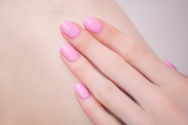 Foto mano femminile con manicure rosa. avvicinamento. salone manicure