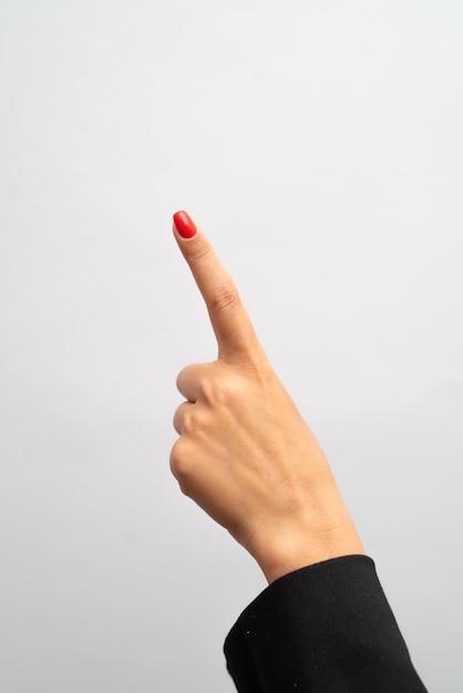 Female hand with red manicure shows gesture on white background