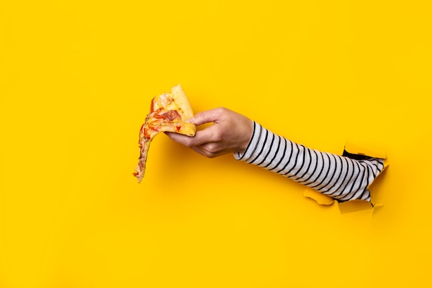 Photo female hand with a slice of fresh hot pizza on a torn