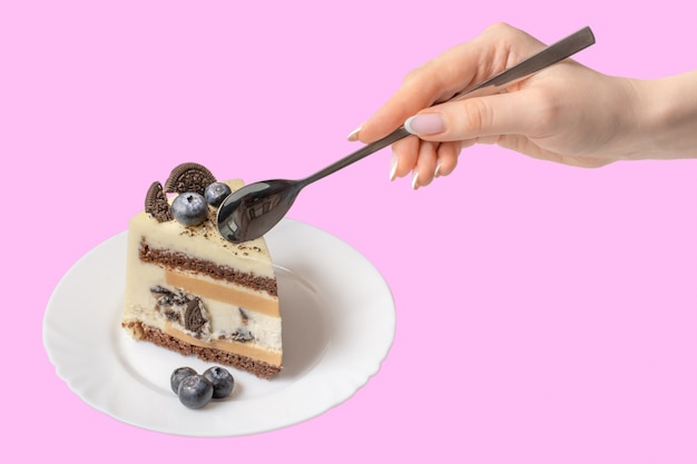 female hand with a spoon eating a cake