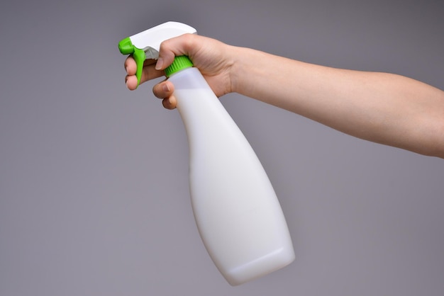 Female hand with sprayer isolated Cleaner's hand holding a white chemical spray bottle