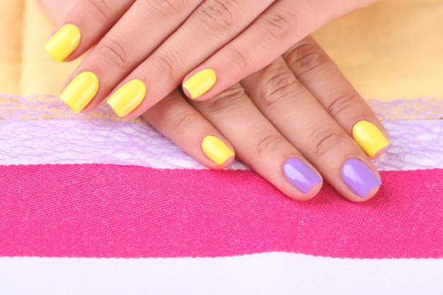 Female hand with stylish colorful nails, on bright