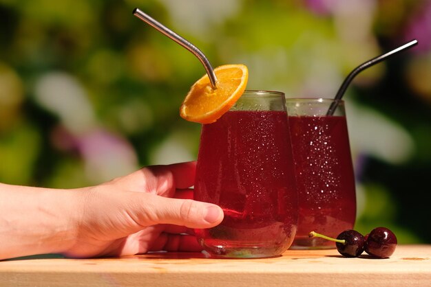 Female hand with summer cherry cocktails