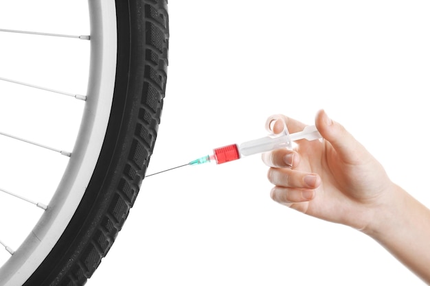 Female hand with syringe and bicycle wheel Doping in sport concept