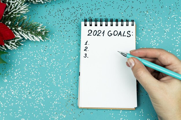 Photo female hand writing 2021 goals for new year resolutions list