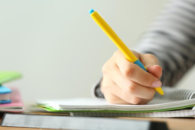 Female hand writing in notebook closeup