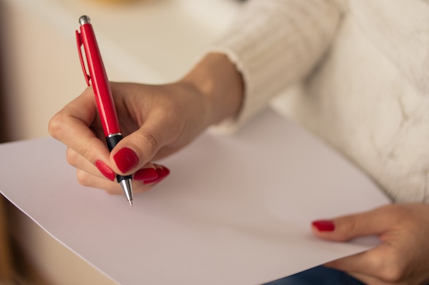 Female hand writing on a sheet of paper