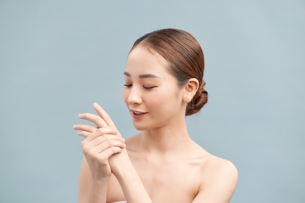 Female hands applying hand cream